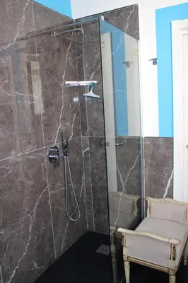 a bathroom with a shower with a glass door at La Maison del Sole in Palermo