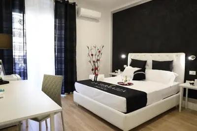 a bedroom with a large white bed with a black wall at La Terrazza Palace B&B in Palermo