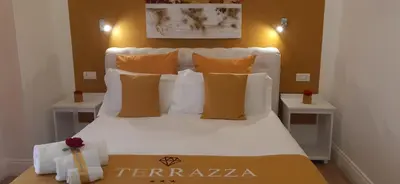 a bedroom with a white bed with orange pillows at La Terrazza Palace B&B in Palermo