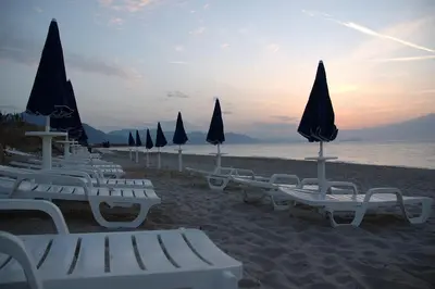 a group of chairs and umbrellas on a beach at Acacia Resort in Campofelice di Roccella