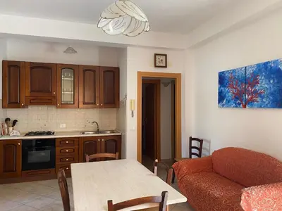 a kitchen and living room with a table and a couch at Case vacanza Cristina site in Antico Baglio e in via Abruzzi n 161 in San Vito lo Capo