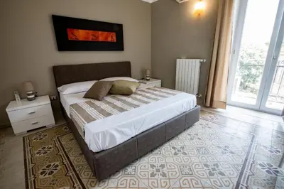 a bedroom with a large bed and a large window at Vittorio Emanuele Appartamenti in Palermo