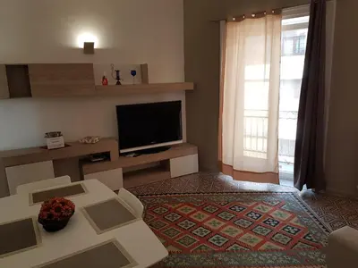 a living room with a tv and a couch and a table at Vittorio Emanuele Appartamenti in Palermo