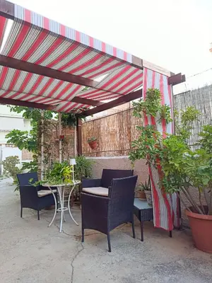 a patio with chairs and a table under a canopy at Appartamentino Cinisi in Cinisi