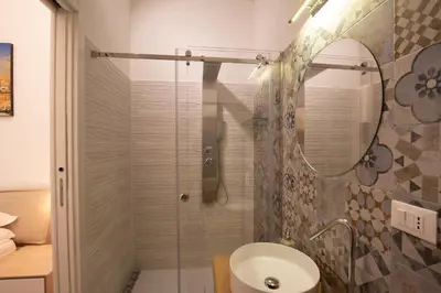 a bathroom with a shower and a sink and a mirror at Sammartino suite in Palermo