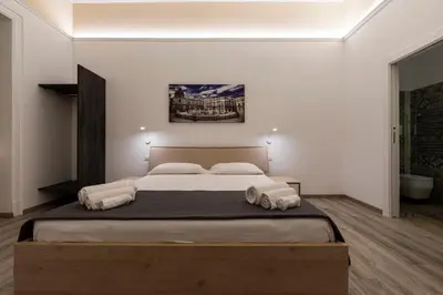 a bedroom with a large bed with white walls at Sammartino suite in Palermo