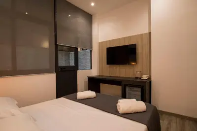 a bedroom with a bed with a tv and a desk at Sammartino suite in Palermo