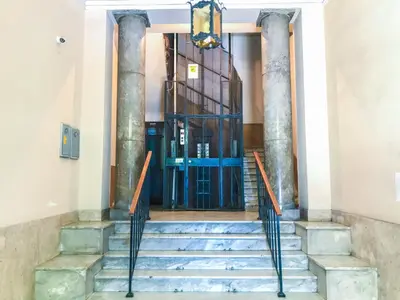 a staircase in the lobby of a building with columns at Sammartino suite in Palermo
