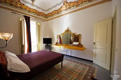 a bedroom with a bed and a mirror on the wall at B&B Casa Ruffino in Balestrate