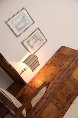 a wooden table with a lamp and pictures on the wall at B&B Casa Ruffino in Balestrate