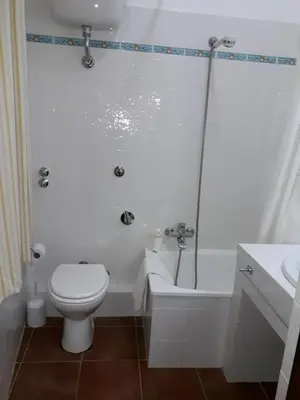 a white bathroom with a toilet and a sink at Le Tre Caravelle in Trabia