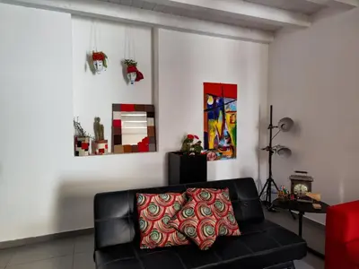 a living room with a black couch and a red pillow at House Il Conte in Palermo