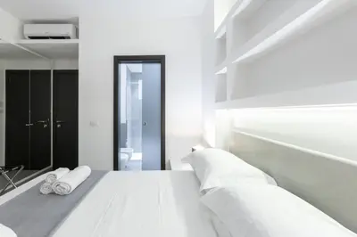 a bedroom with a white bed with towels on it at Suite Palermo Apartment in Palermo