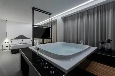 a bathroom with a large tub in a bedroom at Suite Palermo Apartment in Palermo