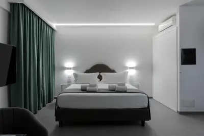 a bedroom with a large bed with green curtains at Suite Palermo Apartment in Palermo