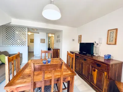 a living room with a wooden table and a television at Villino Addaura in Lido di Mondello
