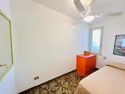 a bedroom with a bed and a dresser and a window at Villino Addaura in Lido di Mondello