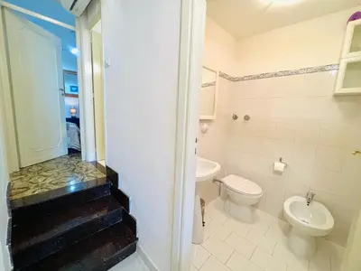 a white bathroom with a toilet and a sink at Villino Addaura in Lido di Mondello