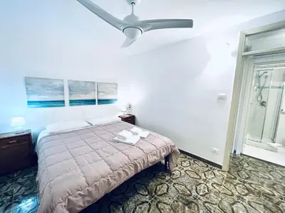a bedroom with a bed and a ceiling fan at Villino Addaura in Lido di Mondello