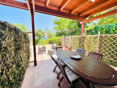 a wooden table and chairs on a patio at Villino Addaura in Lido di Mondello