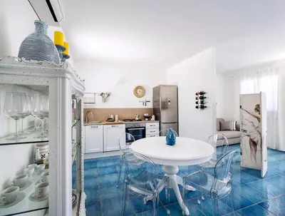 a white kitchen with a white table and chairs at Spuma di Mare - Riccio in San Vito lo Capo