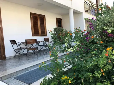 a patio with chairs and a table and flowers at Case Vacanza appartamenti Trinacria in San Vito lo Capo