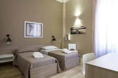 a hotel room with two beds and a table at Bagnasco 18 suite&terrace in Palermo