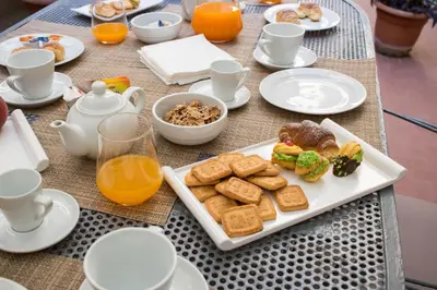 a table with a plate of breakfast foods and orange juice at Bagnasco 18 suite&terrace in Palermo