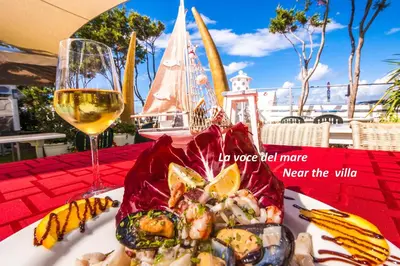 a plate of food on a table with a glass of wine at Villa Arvilla with Private POOL in Campofelice di Roccella