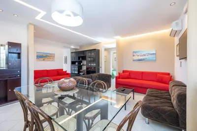 a living room with a glass table and red couches at Villa Arvilla with Private POOL in Campofelice di Roccella