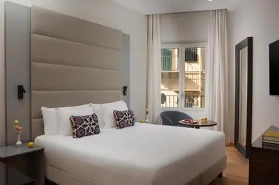 a bedroom with a large white bed and a window at NH Collection Palermo Palazzo Sitano in Palermo