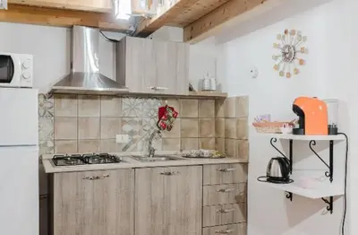 a kitchen with a sink and a stove top oven at La casa di Anita nel cuore di Segesta in Calatafimi