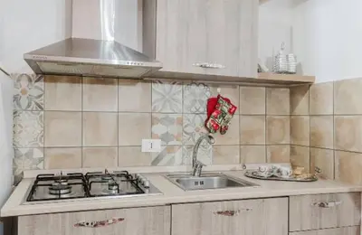 a kitchen counter with a sink and a stove at La casa di Anita nel cuore di Segesta in Calatafimi