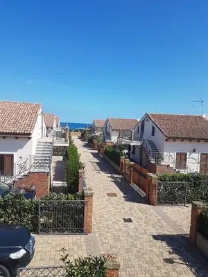 a residential street with houses and a fence at Mansarda Camelie via dei Normanni, 45 in Campofelice di Roccella