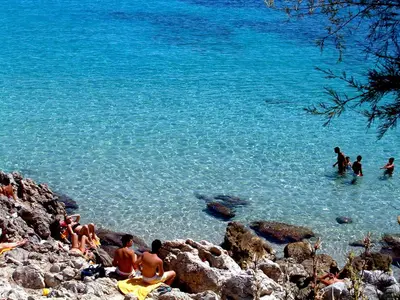 a group of people in the water at a beach at Casa Relax Mondello in Mondello
