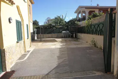 an alley with a fence and a cow in a yard at La Casa Gialla in Trabia