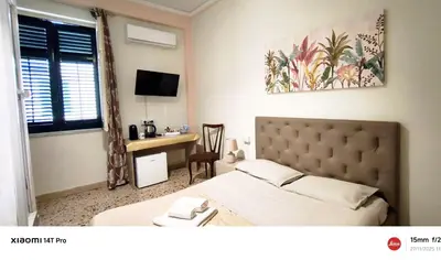 a bedroom with a bed and a desk and a window at Stella Maris in Palermo