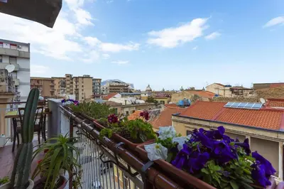 a balcony with flowers and a view of a city at Stella Maris in Palermo