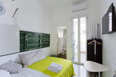 a kitchen with white cabinets and a table and chairs at La terrazza del Sole B&B in Palermo