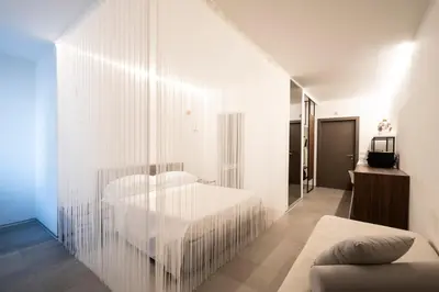 a bedroom with a white bed and a glass wall at Alkamuri Posh Hotel e Spa in Alcamo
