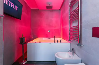 a red bathroom with a white tub and a sink at Quinto Stabile Rooms&Suite in Palermo
