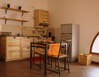 a kitchen with a table and chairs and a refrigerator at palermo casa vacanze in Palermo