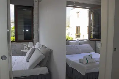 a room with two beds and a couch and a window at Villa Degli Ulivi Flora in Mondello