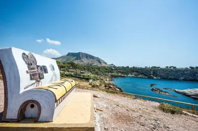 a bench with a painting on it next to the water at Calarossa Seaview by Wonderful Italy in Terrasini