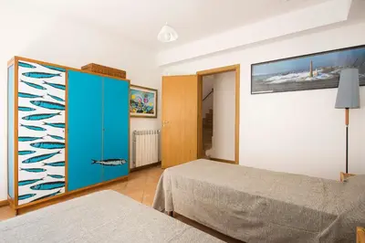 a bedroom with a bed and a blue cabinet at Calarossa Seaview by Wonderful Italy in Terrasini