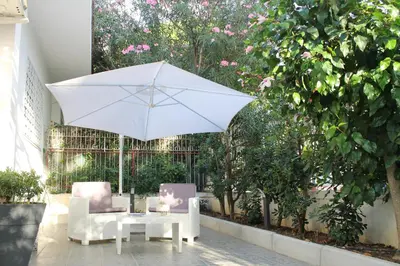 a white table and two chairs and an umbrella at Casa Vacanza Peppino! in Palermo