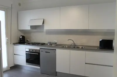 a kitchen with white cabinets and a sink at Casa Vacanza Peppino! in Palermo