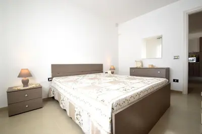 a bedroom with a large bed and two night stands at Villa Bianca e Villa Arancio in Alcamo