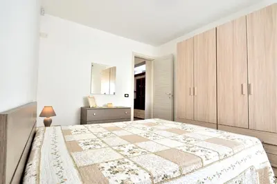 a white bedroom with a large bed and a mirror at Villa Bianca e Villa Arancio in Alcamo