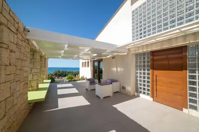 an outdoor patio with chairs and a building at Villa Perla del Mare in Alcamo Marina